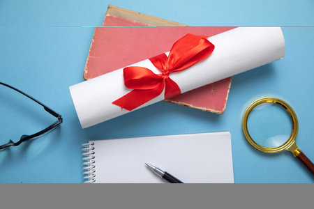 Diploma and business objects on the blue background.の写真素材