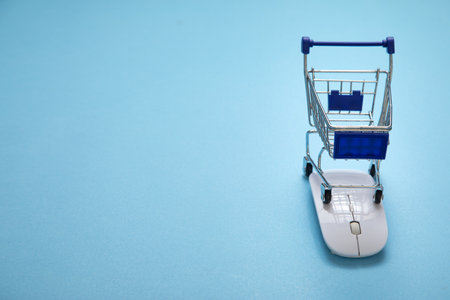 Shopping cart and computer mouse on the blue background.の写真素材