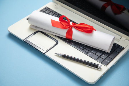 Diploma, pen on the laptop keyboard.の写真素材