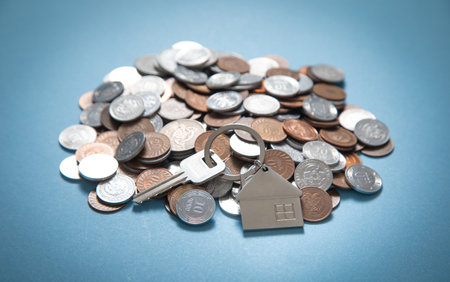 House keys over stack of coins.の写真素材