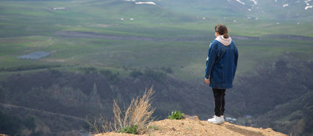 Young tourist enjoys at the top mountain.