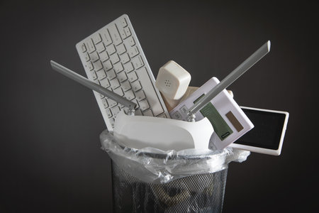 Computer keyboard, calculator and other objects on the trash.