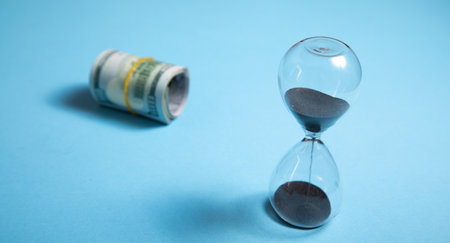 Hourglass with a dollar banknote. Business