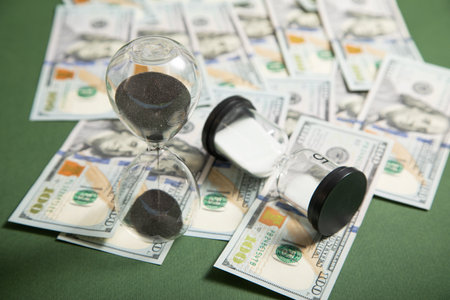 Hourglass with a dollar banknote. Business