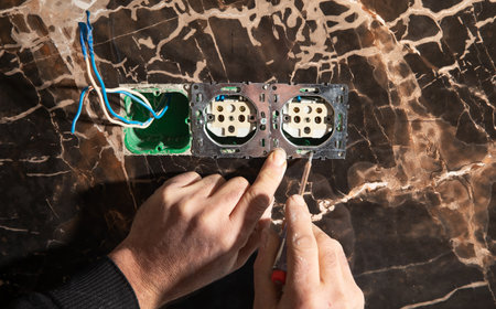 Electrician installing a wall socket at home.