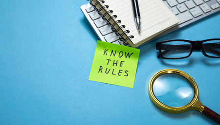 Know The Rules on sticky note with a business objects on the blue background.の写真素材