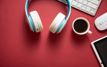 White wireless headphones and other objects on the bordeaux background.の写真素材