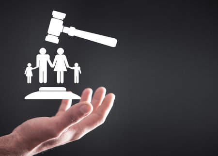 Male hand holding judge gavel with a family symbol. family lawの写真素材