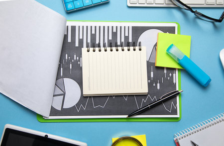 Empty notepad with a financial graphs and other business objects.