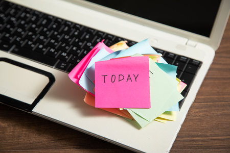 Laptop computer with Today word on colorful sticky notes.の写真素材
