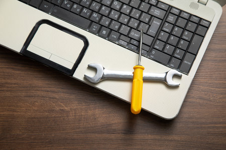 Wrench and screwdriver with a laptop computer. IT Service. Support