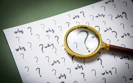 Question marks and Why? word with magnifying glass.の写真素材