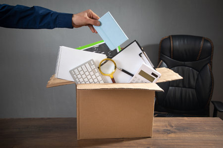 Businessman with a cardboard box and business objects. Job loss. Unemployment