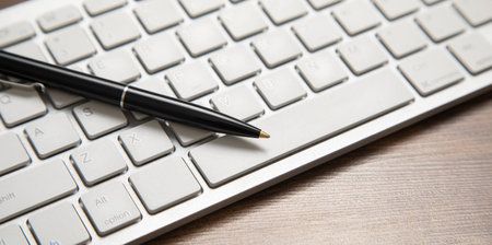 Black pen on the computer keyboard.