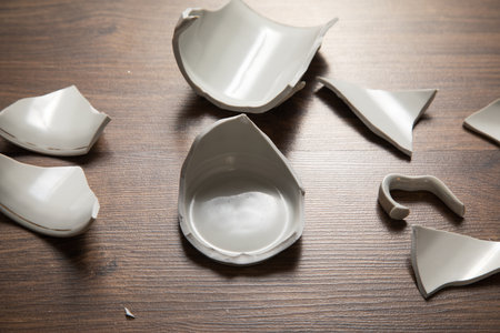 White broken cup on the wooden background.の写真素材