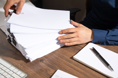 Caucasian businessman holding documents in office.