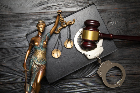 Statue of Lady Justice, handcuffs, book and gavel.の写真素材
