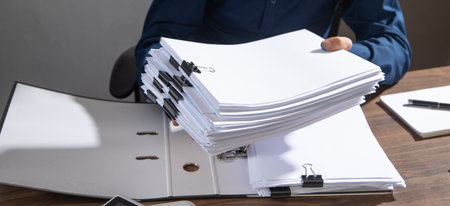 Caucasian businessman holding documents in office.