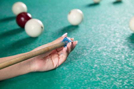 Caucasian young girl playing billiards.