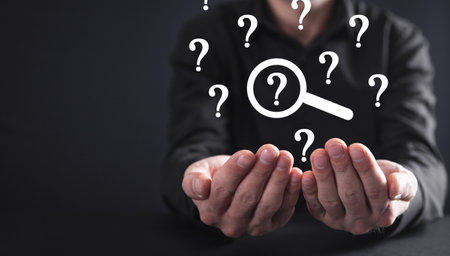 Male hand showing magnifying glass with a Question mark.の写真素材