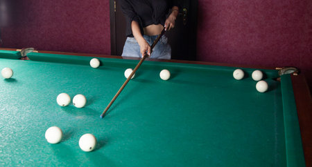 Caucasian young girl playing billiards.