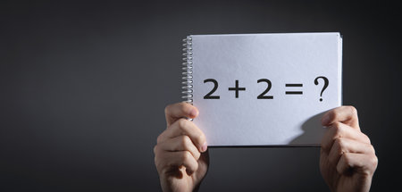 Man showing 2+2=? in notepad. Business concept