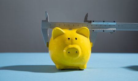 Piggy bank with vernier caliper on the blue background.の写真素材