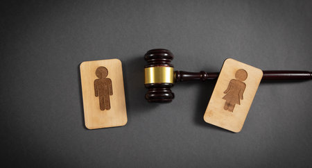 Judge gavel with a male and female wooden symbols on the black background.の写真素材