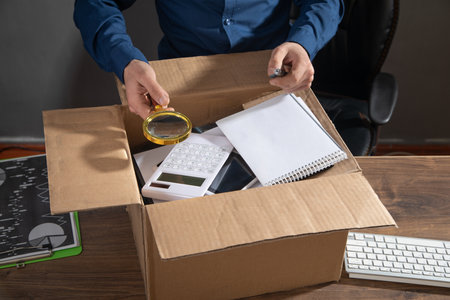 Businessman with a cardboard box and business objects. Job loss. Unemployment
