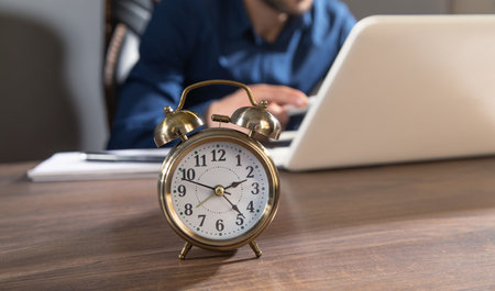 Businessman working at office with an alarm clock on the table.の写真素材