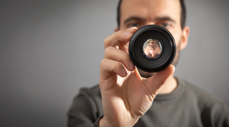 Man looking through camera lens.