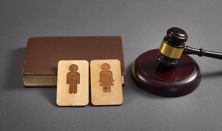 Judge gavel with a male and female wooden symbols on the black background.の写真素材