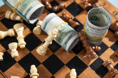 Chess figures and dollar money on the chessboard.の写真素材