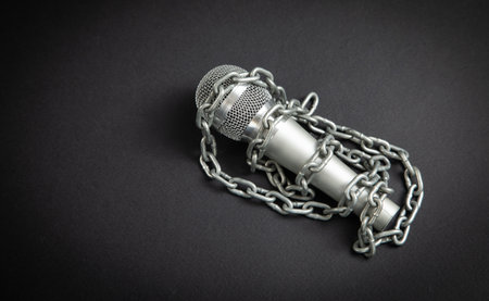 Microphone tied with chains on the black background.の写真素材
