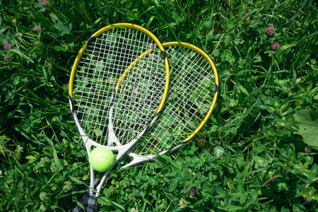 Tennis ball and racket on the green grass background.の写真素材