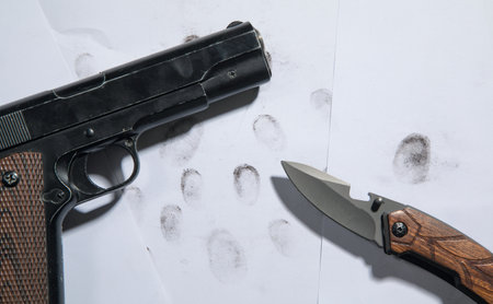 Pistol and knife on fingerprints ID for criminal.の写真素材