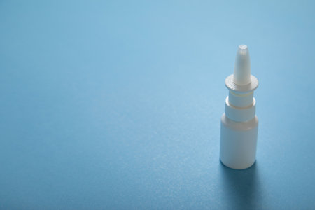 White nose spray bottle on the blue background.の写真素材