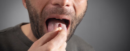 Man taking medicine pill at home.の写真素材