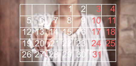Human showing calendar with a black and red numbers.の写真素材