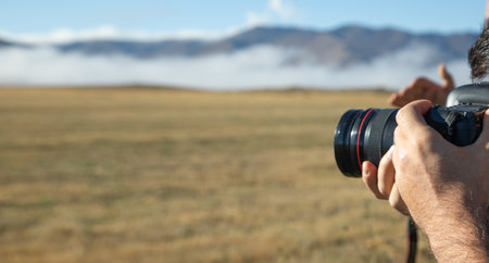 Man holding dslr camera in outdoor.の写真素材