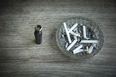 Ashtray, cigarettes and lighter on the table.の写真素材