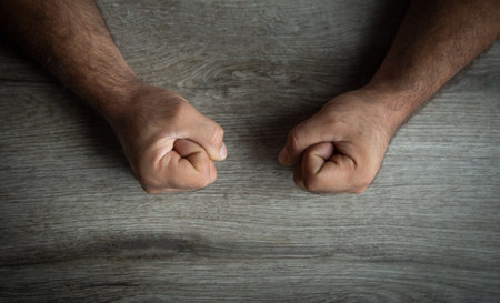 Fists of angry man beats on the table.の写真素材
