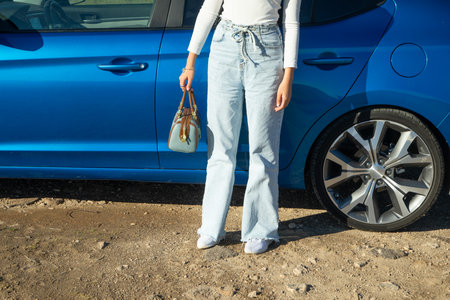 Woman with handbag near the car.
