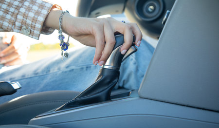 Female hand switches gear shift lever in the car.の写真素材