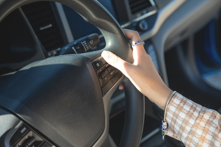 Female hands in steering wheel of car.の写真素材