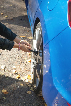 Young woman checking of car tire.の写真素材
