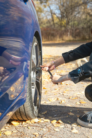 Young woman checking of car tire.の写真素材