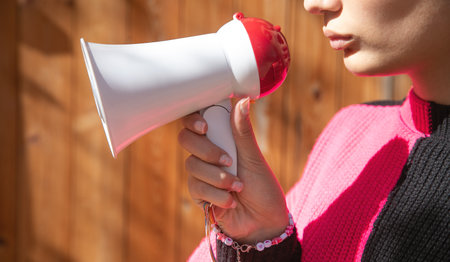 Caucasian young woman holding megaphone.の写真素材