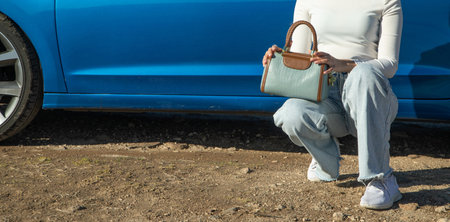 Woman with handbag near the car.の写真素材