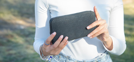 Young woman showing wallet. fashion